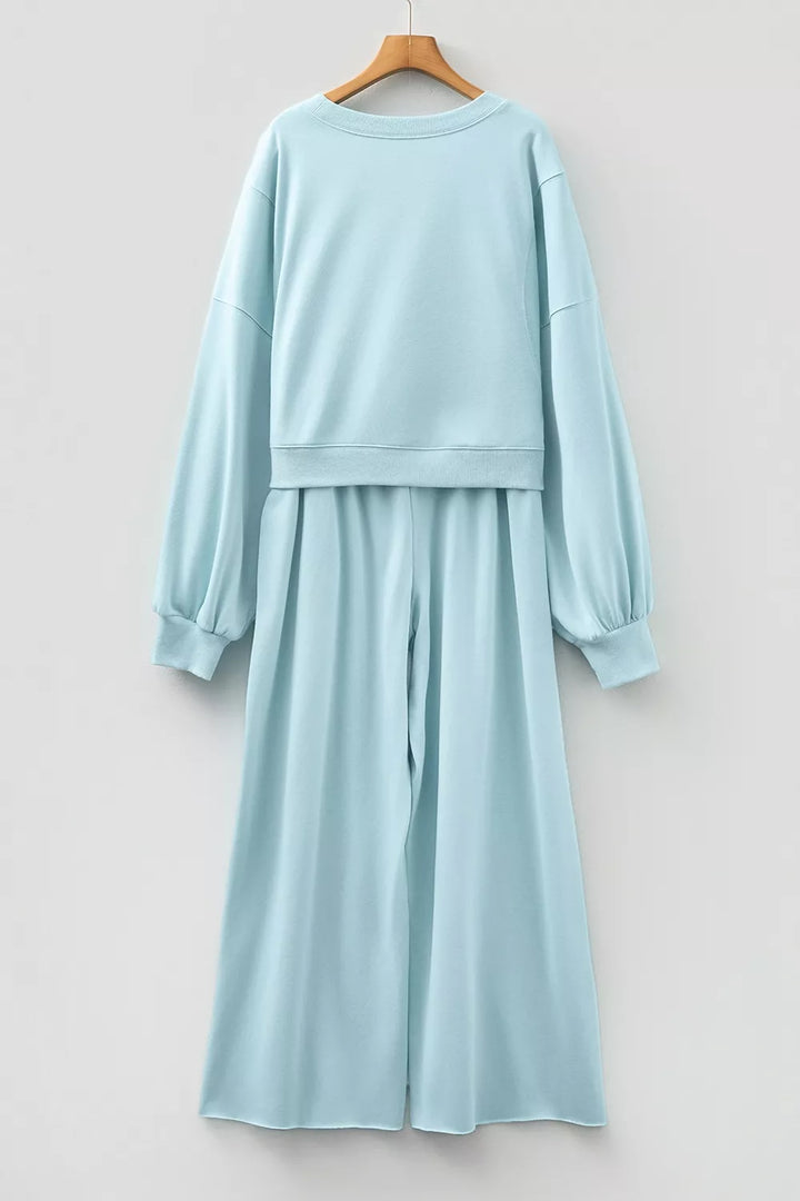 Back view of the pastel blue cropped pullover and wide leg pants on a hanger