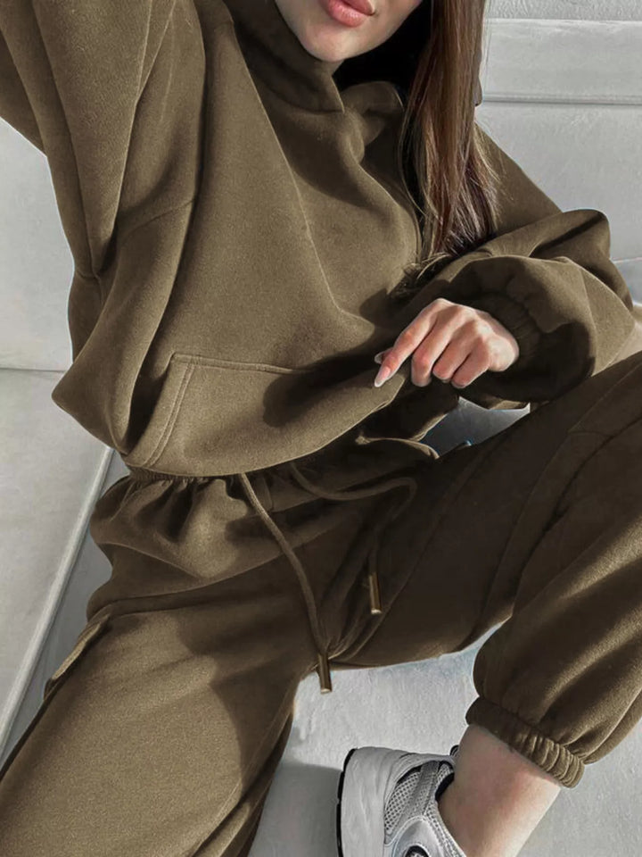Olive hoodie and cargo joggers set, seated pose with drawstring waist visible