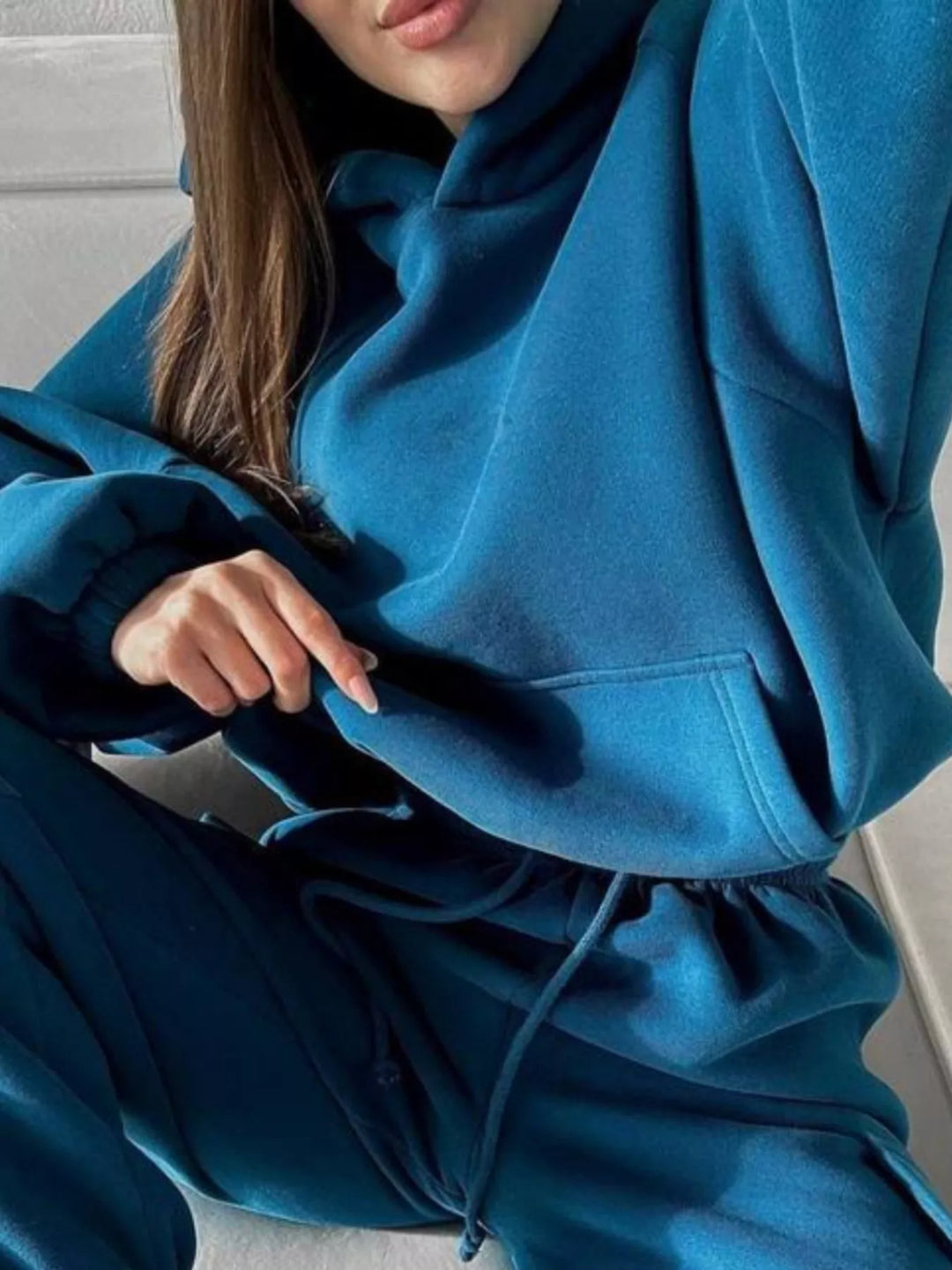 Teal blue hoodie kangaroo pocket and drawstring waistband up close