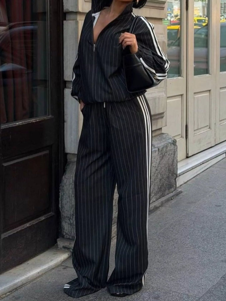 Women's black pinstripe tracksuit set with zip jacket and wide leg pants, full length