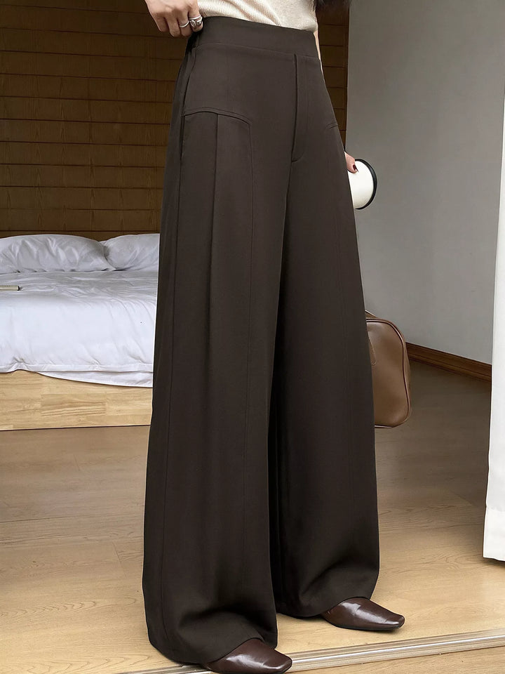 Front view of the coffee brown pleated trousers worn with brown loafers