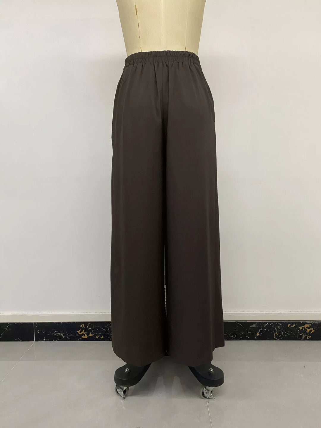 Coffee brown wide leg trousers on a mannequin, front view
