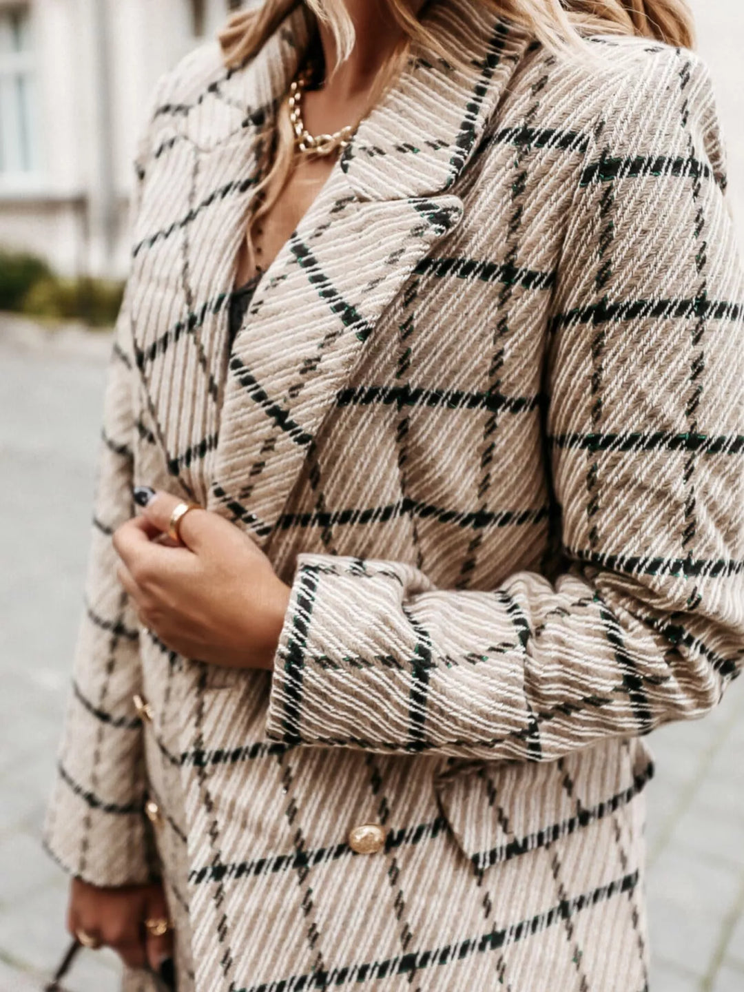 Close-up of the beige plaid blazer lapel and gold buttons