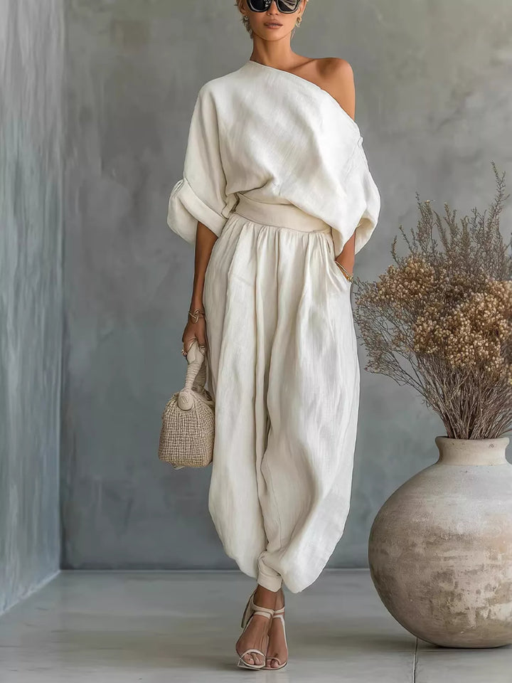 Ivory one shoulder top and balloon pants set, full length with a small handbag