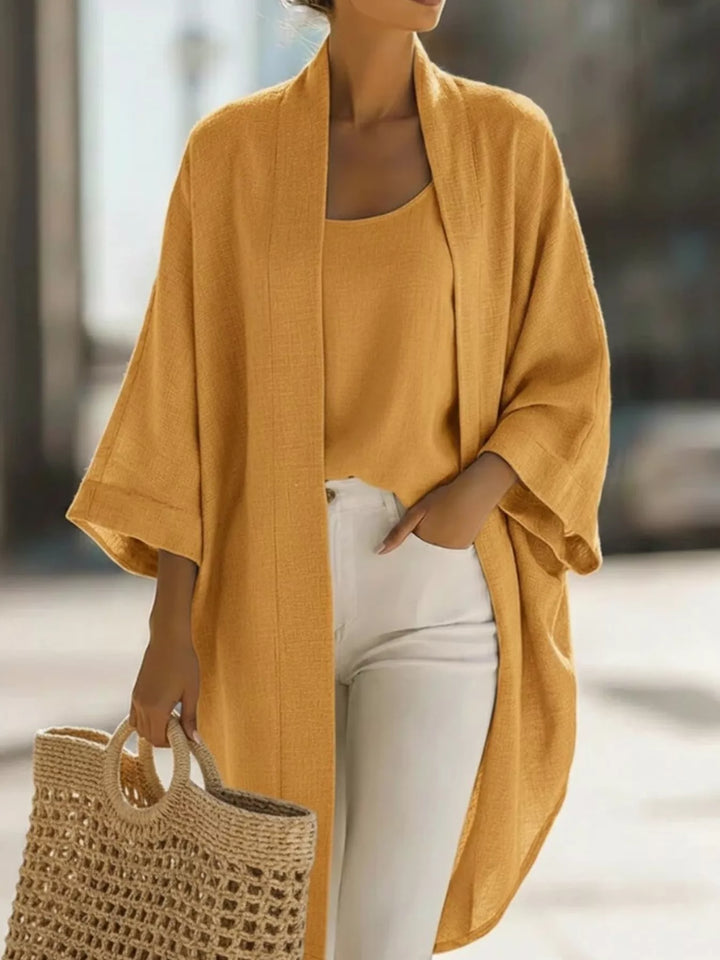 Mustard kimono cardigan and tank set with white pants and woven handbag