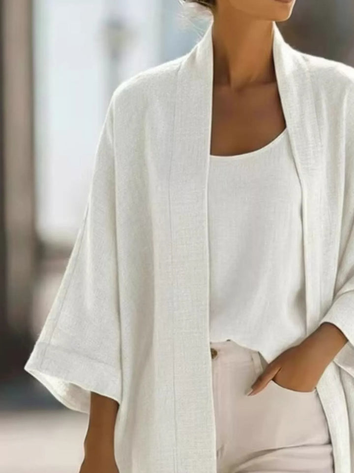 Close-up of the white open front cardigan and tank with a hand in the pocket