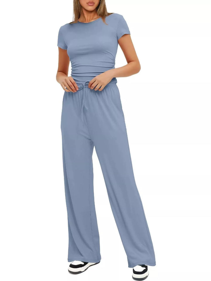Light blue crop top and pants set standing with hands at the waist
