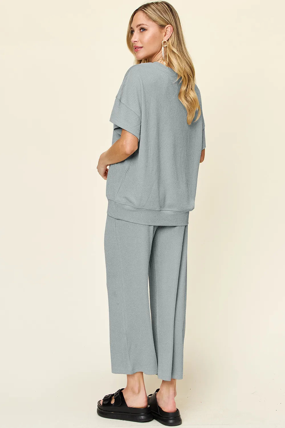 Back view of the dusty blue two piece set with chunky sandals