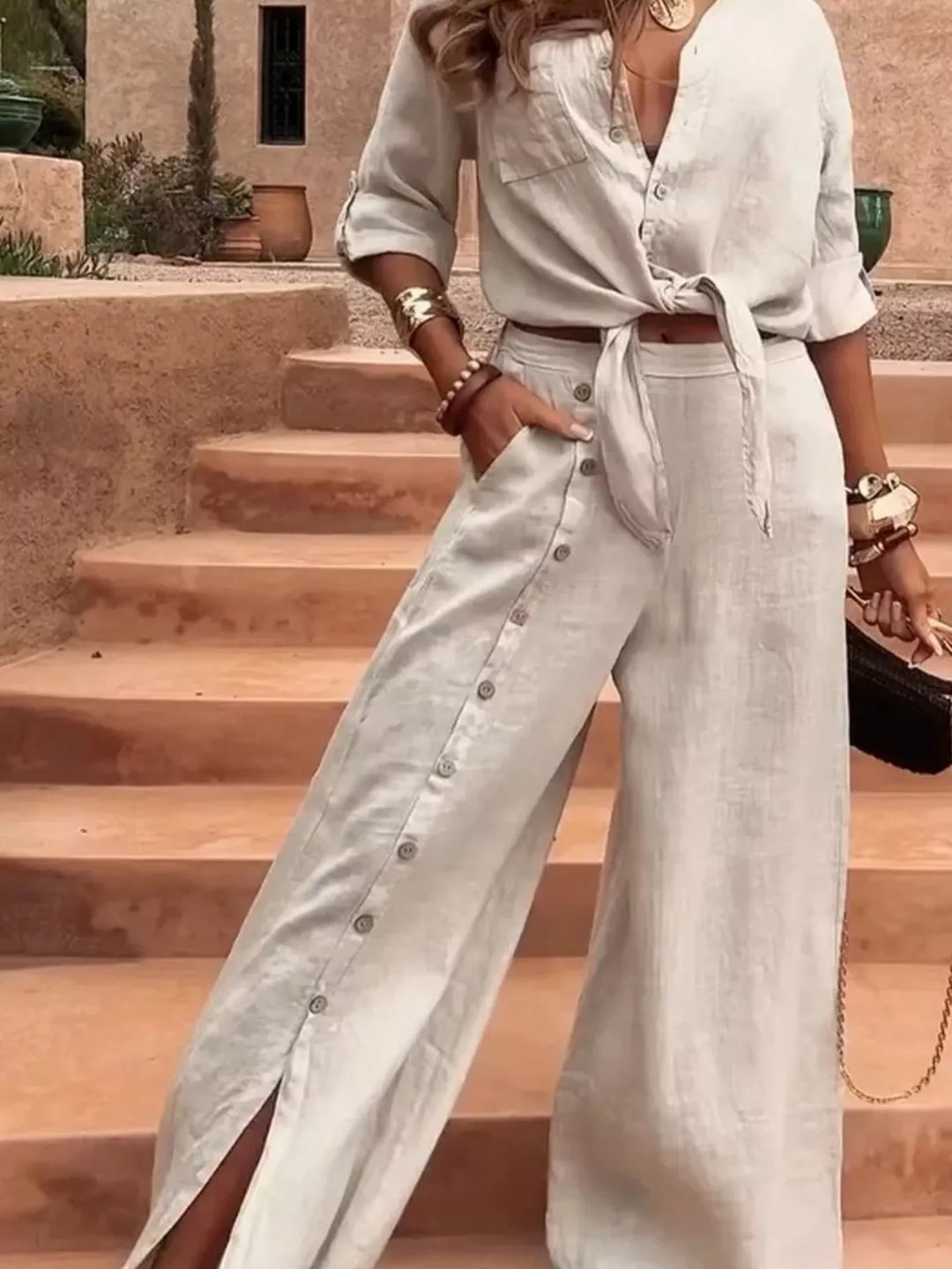 Women's apricot two piece set with tie front shirt and wide leg pants on stone steps