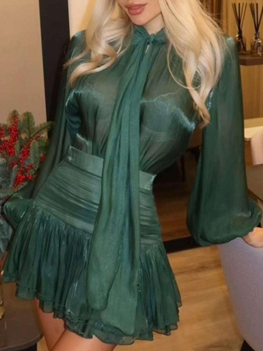 Emerald bow tie blouse and ruffle mini skirt set, seated pose with holiday decor