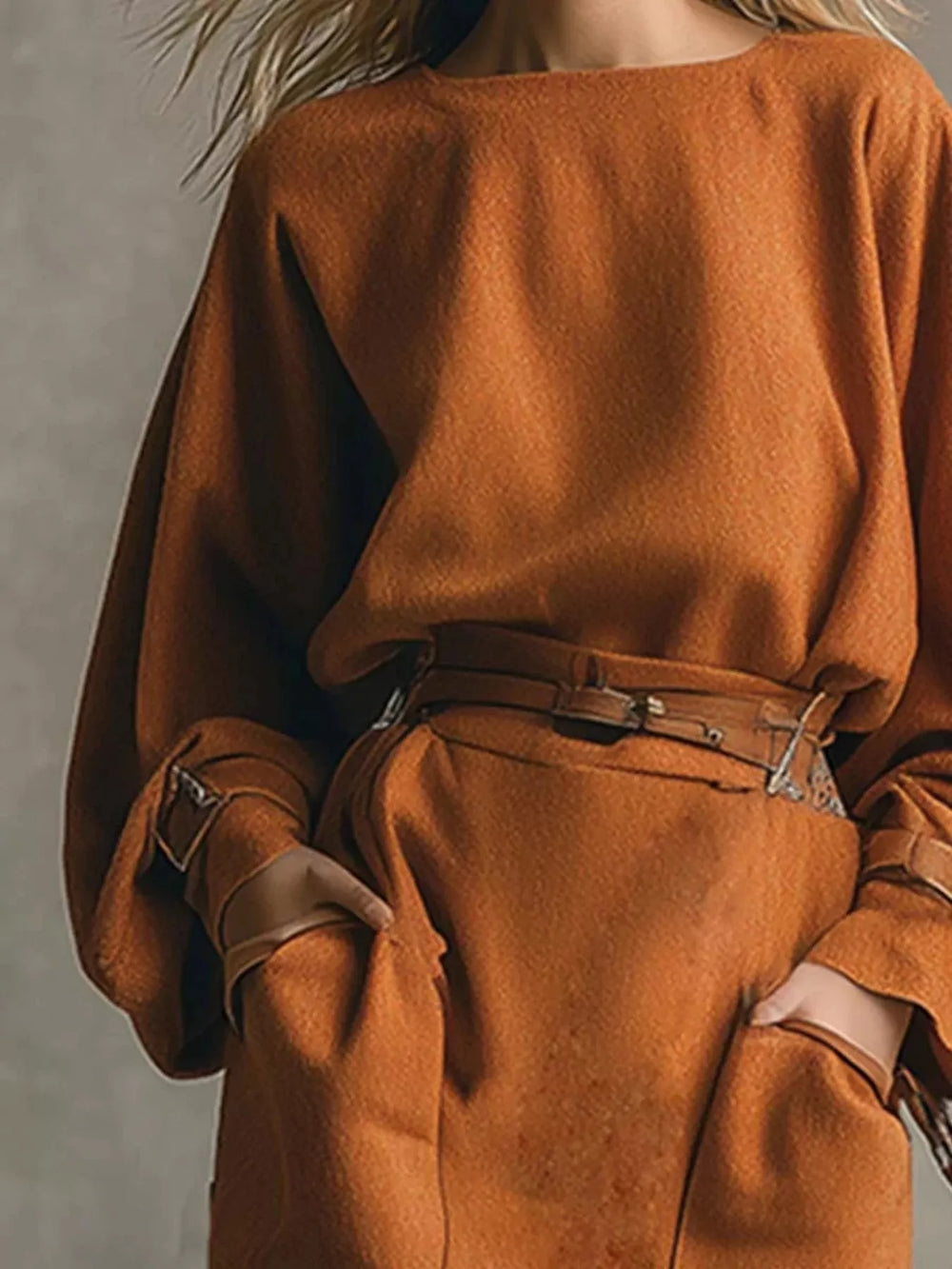 Close-up of the rust oversized top and belted waist of the skirt set
