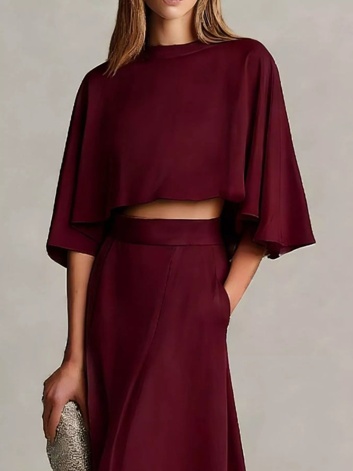 Burgundy cropped flutter sleeve top and maxi skirt with a silver clutch