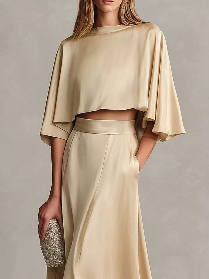 Champagne satin look cropped top and maxi skirt with a sparkly clutch, front view