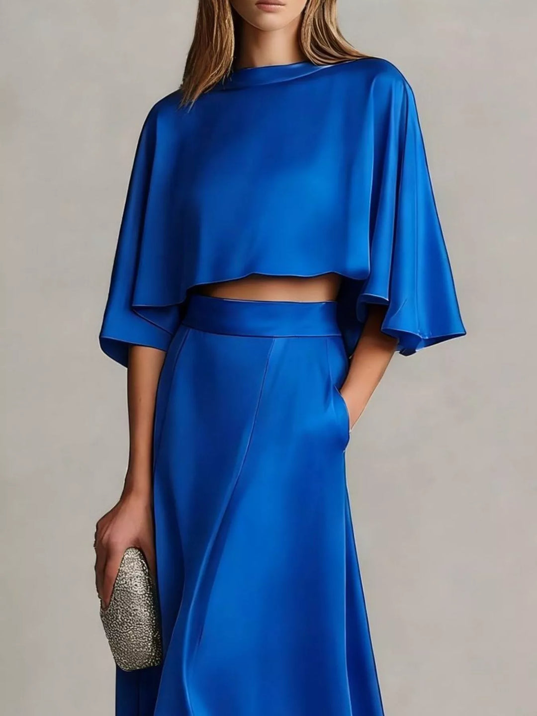 Royal blue two piece skirt set with a cropped flutter sleeve top and clutch
