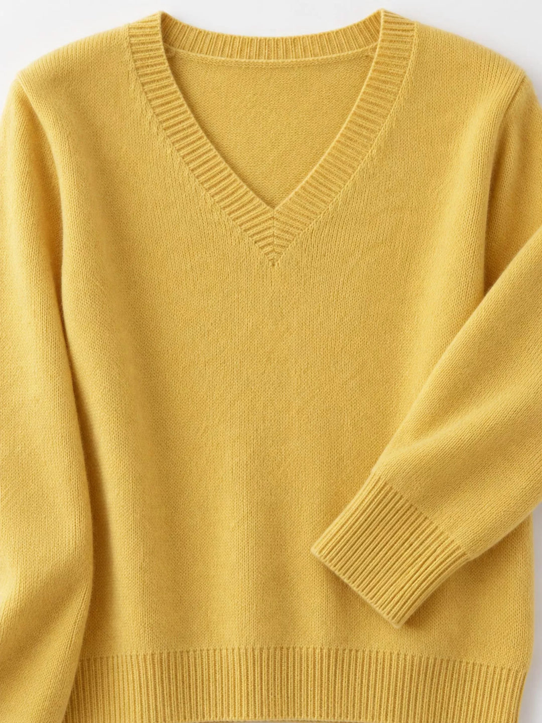 Close-up details of the yellow sweater neckline, ribbed cuff and hem