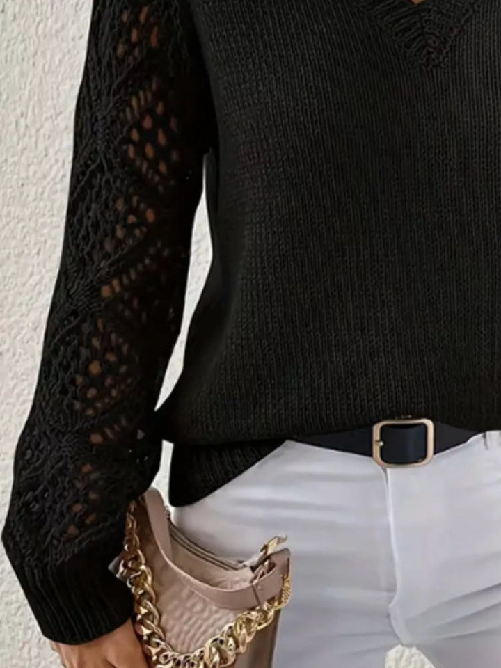 Close-up of the black openwork sleeve and belted waist of the v neck sweater