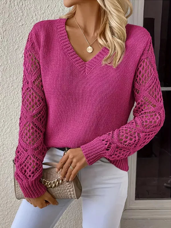 Fuchsia v neck sweater held at the hip with a small chain bag