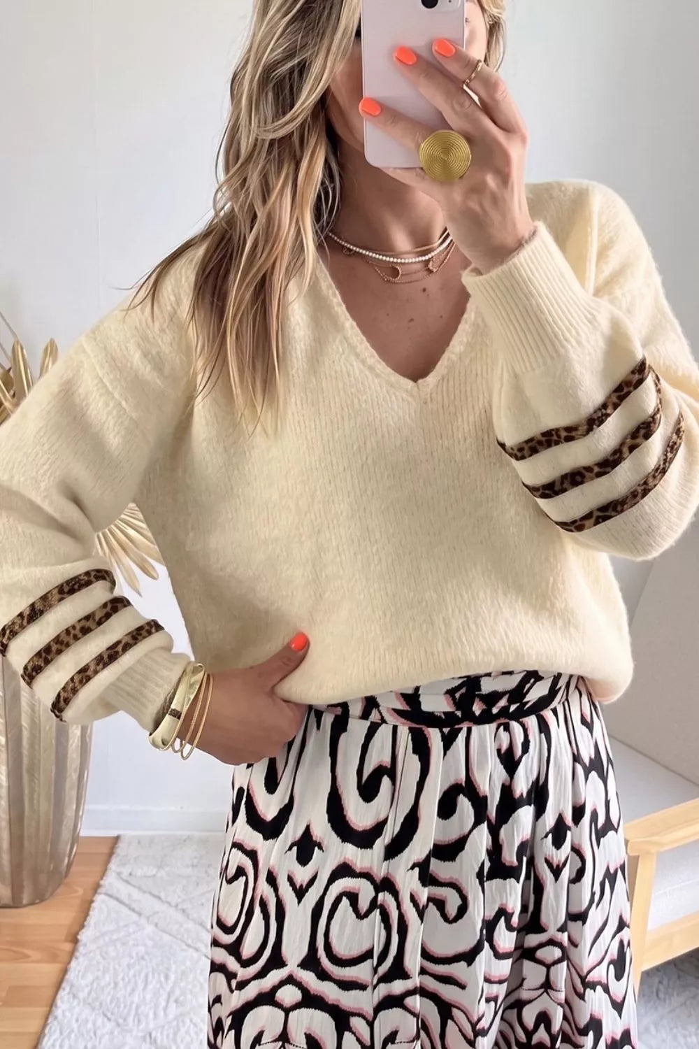 Women's v neck sweater in cream soft knit with striped cuffs, styled with a printed skirt