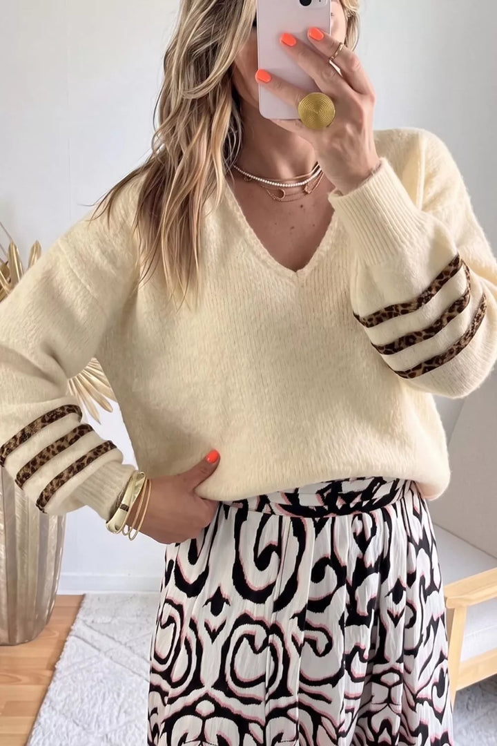 Women's v neck sweater in cream soft knit with striped cuffs, styled with a printed skirt