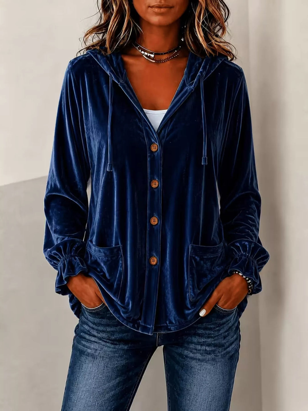 Navy blue velvet jacket with ruffled cuffs worn open with jeans