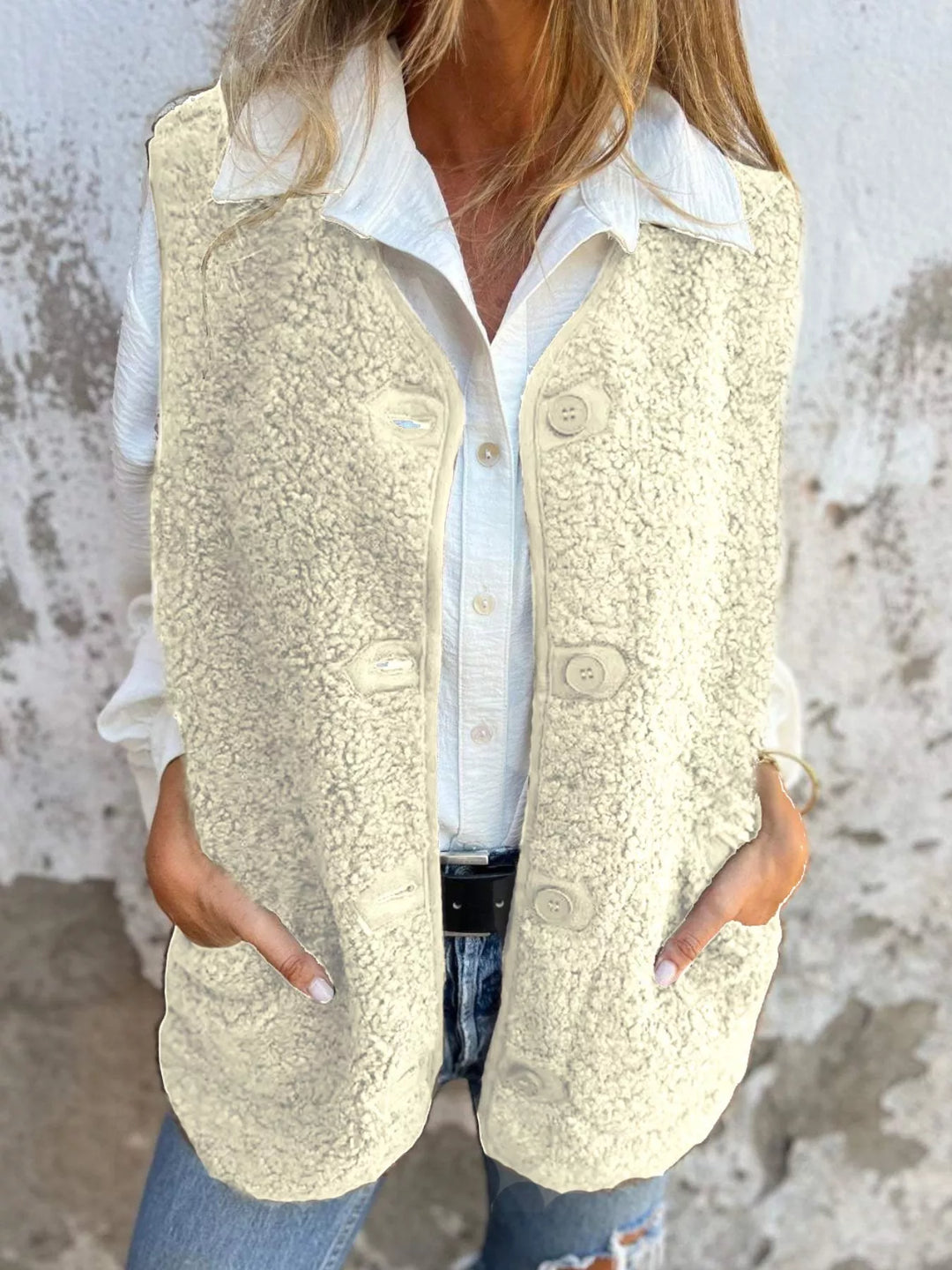 Cream fluffy sleeveless vest with buttons worn over a white shirt and jeans