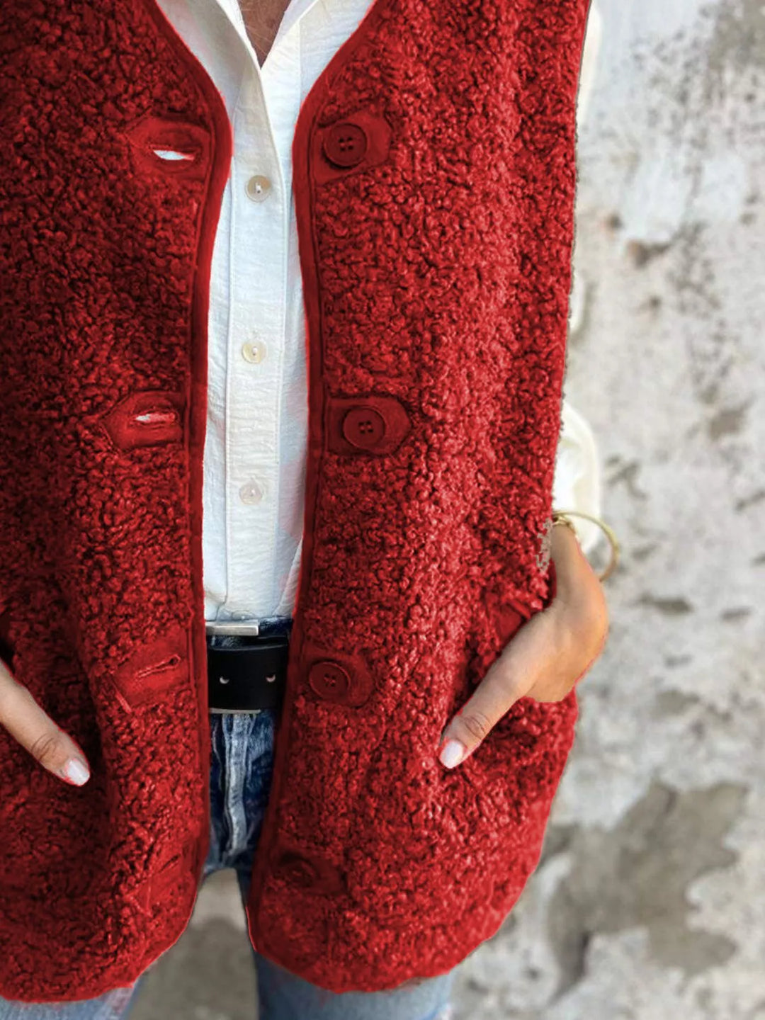 Red textured sleeveless vest, close-up of the button placket and pocket