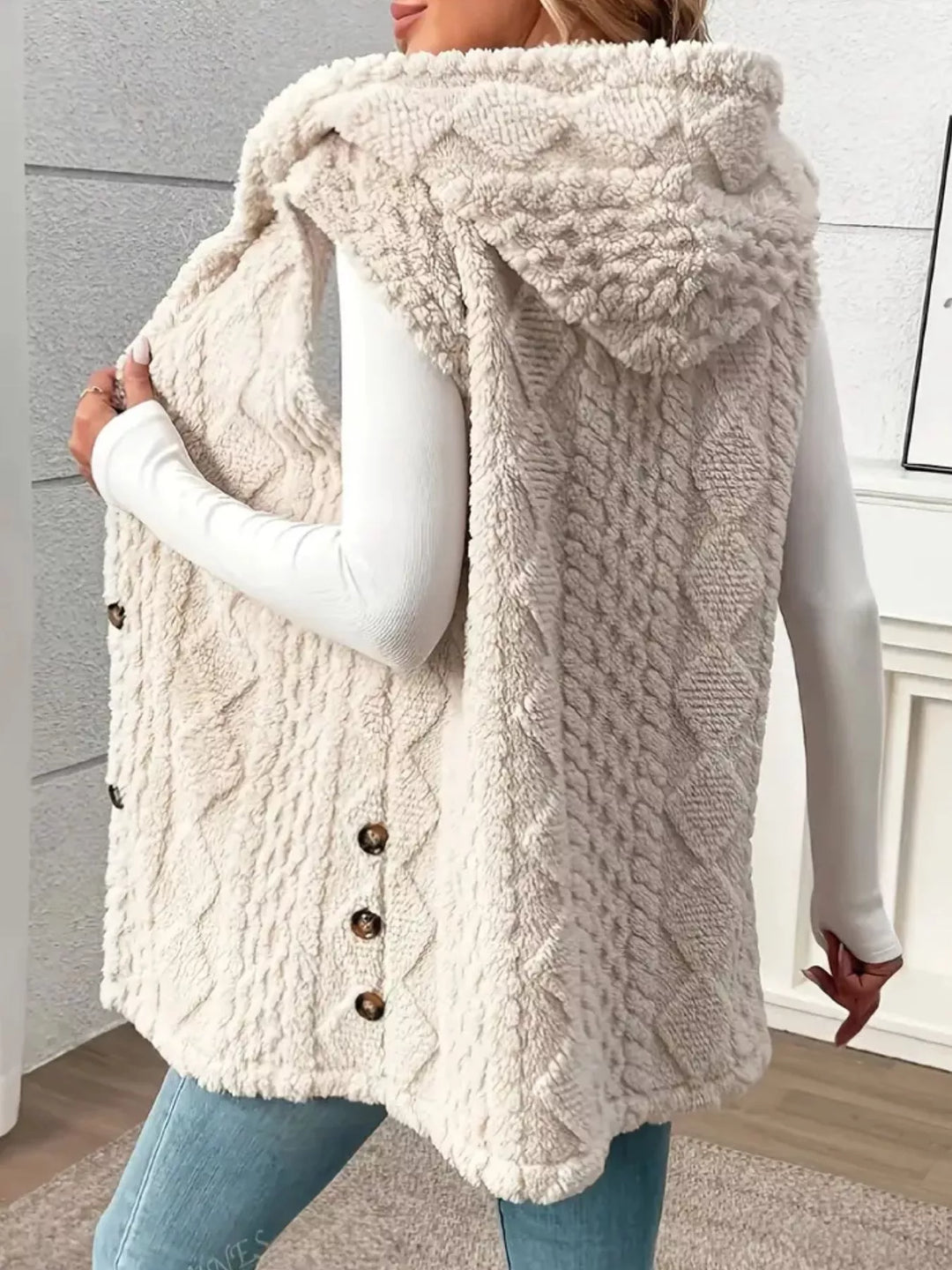 Beige hooded cable knit vest from the back showing the hood and side buttons
