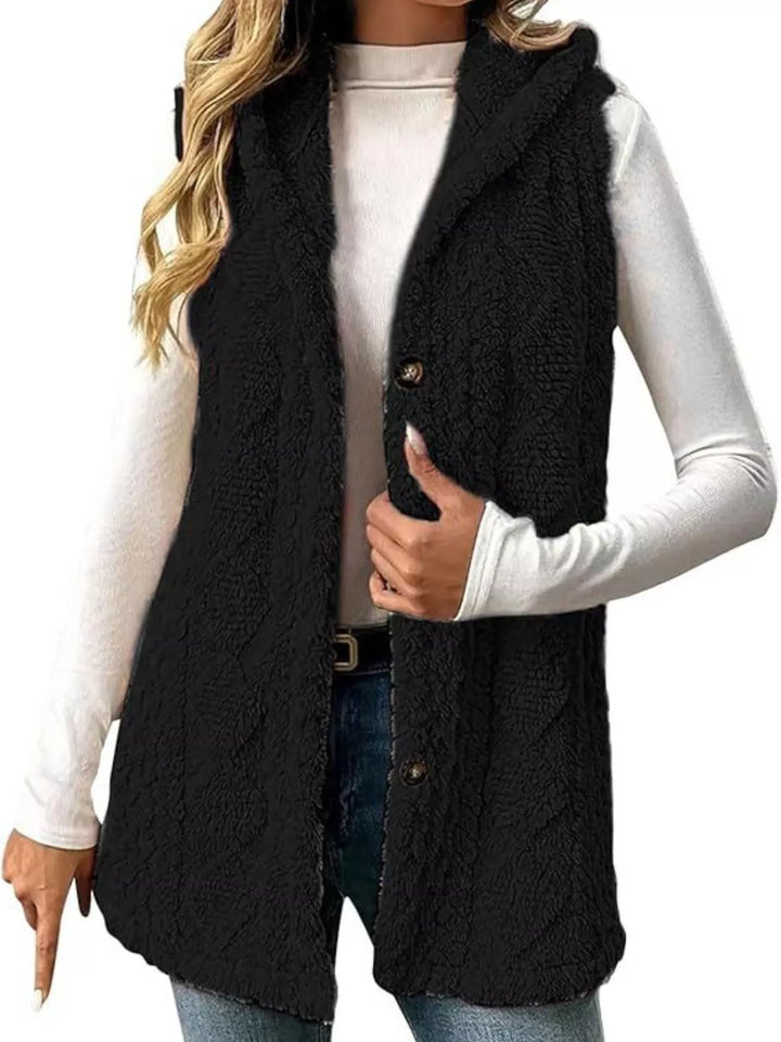 Black hooded fuzzy cable knit vest with button front over a white top