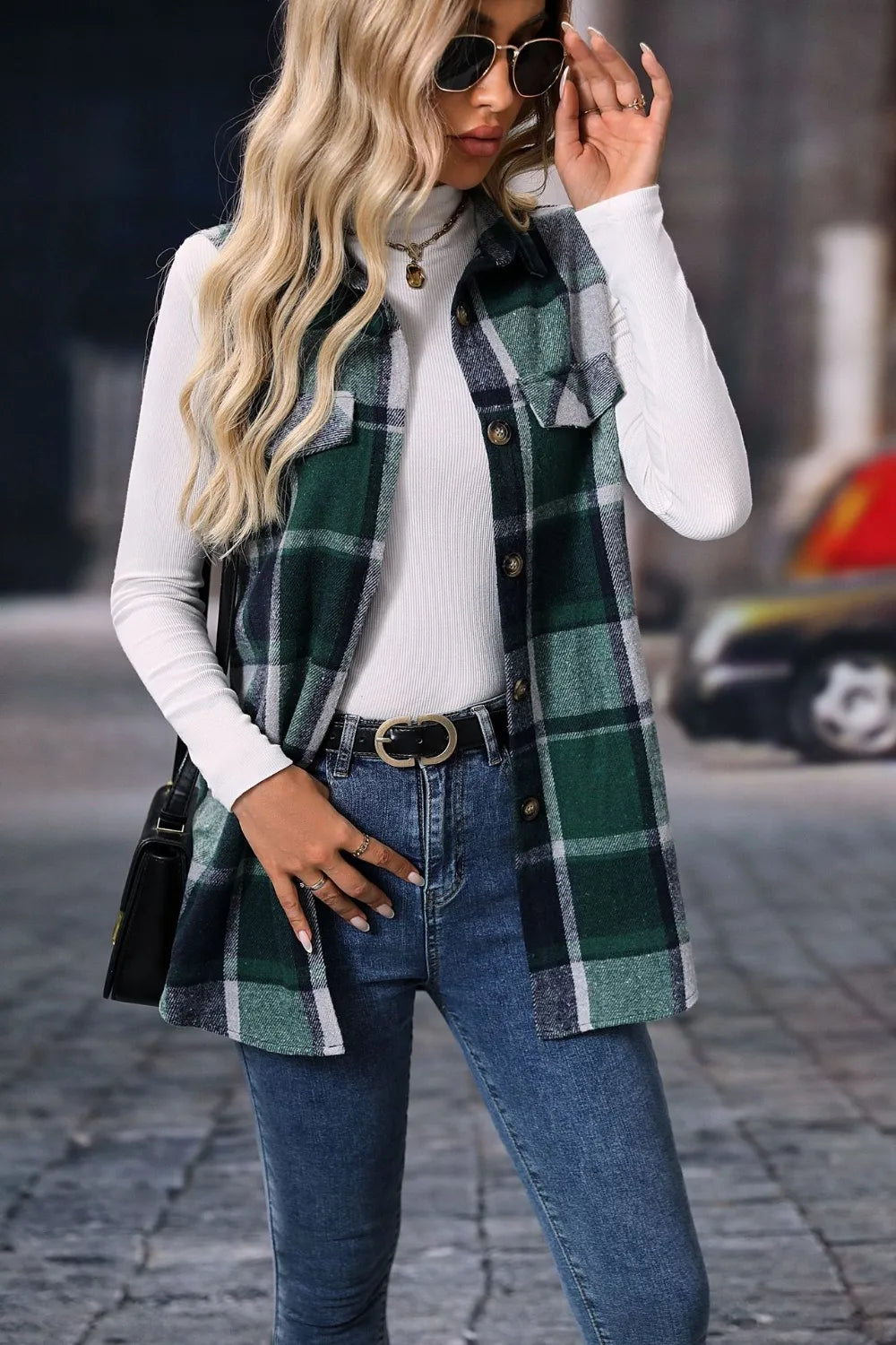 Dark green plaid longline vest worn with sunglasses and a black bag