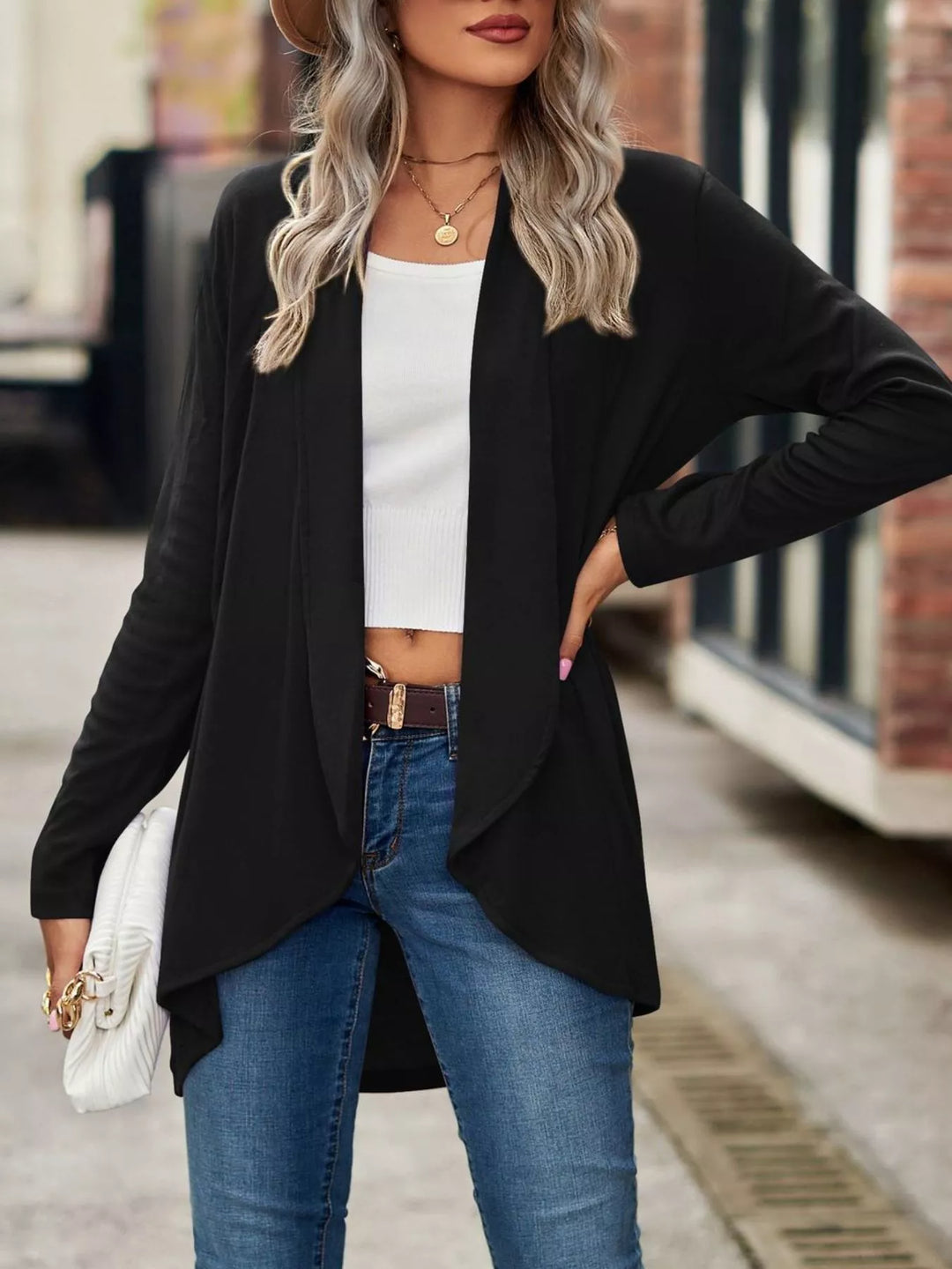 Black high low hem cardigan with hand on hip, worn open over white top