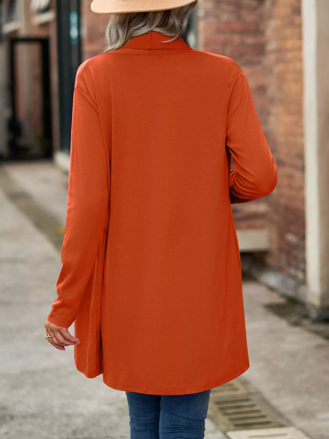 Back view of the burnt orange long cardigan with curved hem