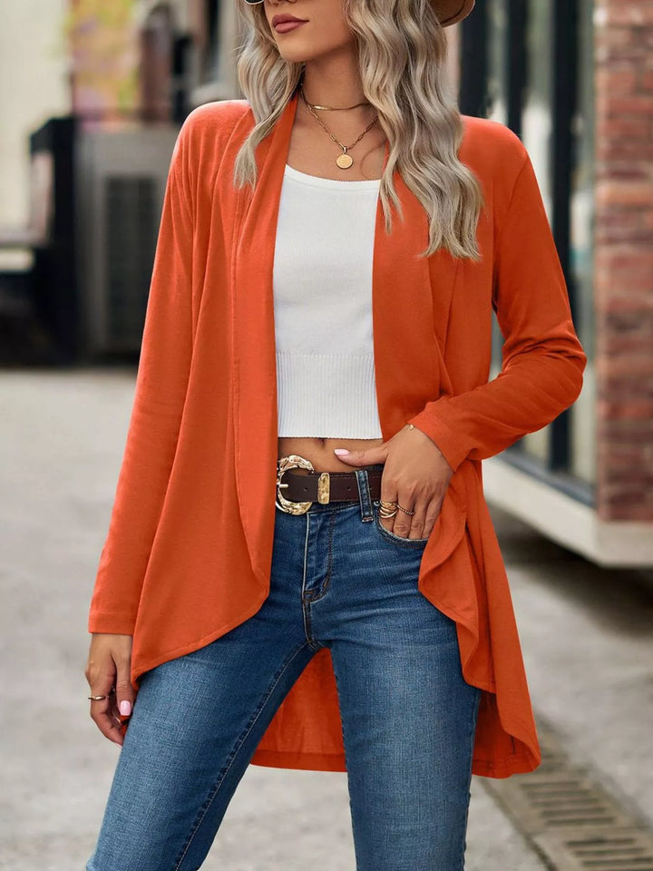 Burnt orange high low hem cardigan worn open with belted jeans