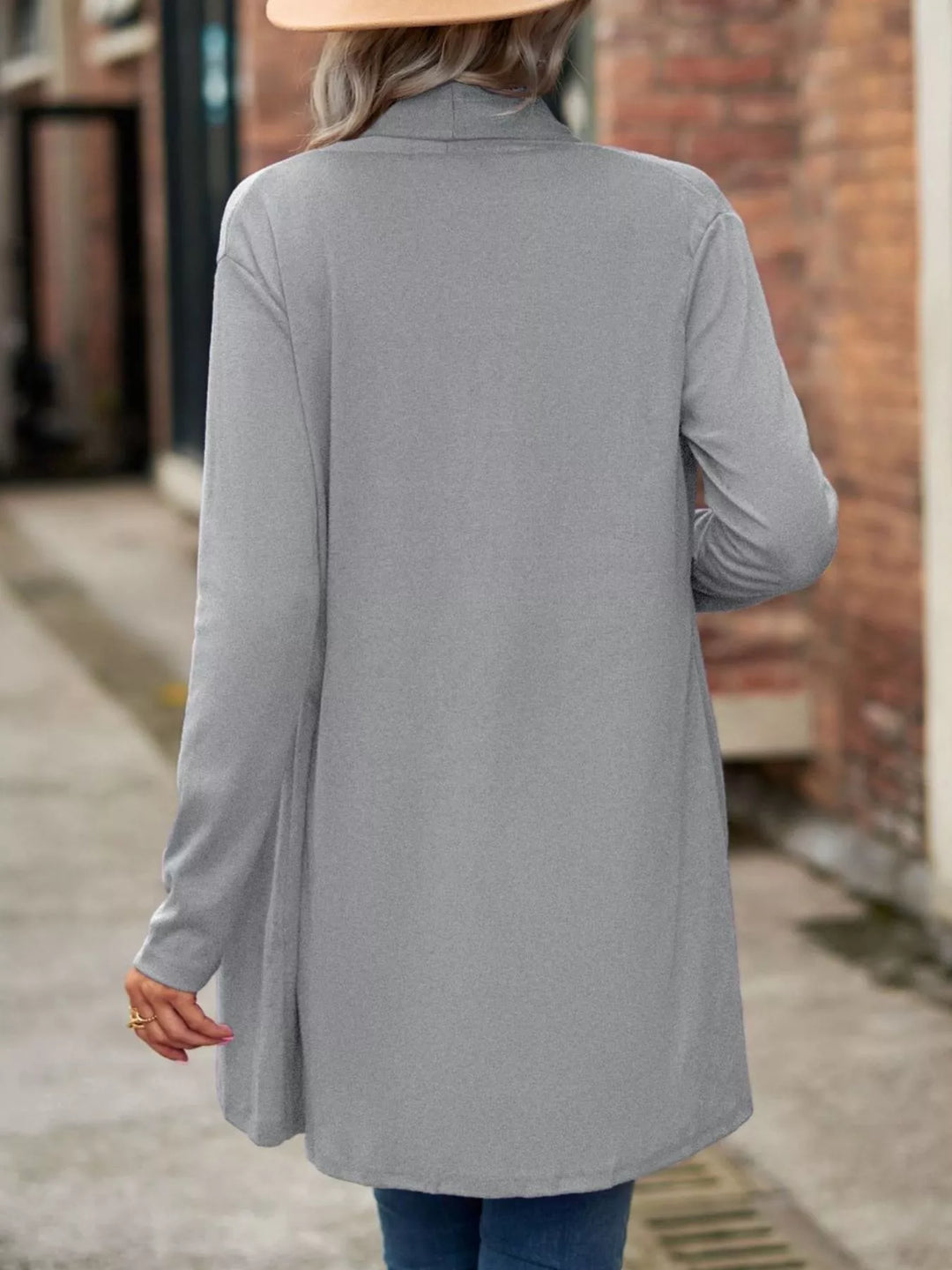Back view of the light gray long cardigan with curved hem
