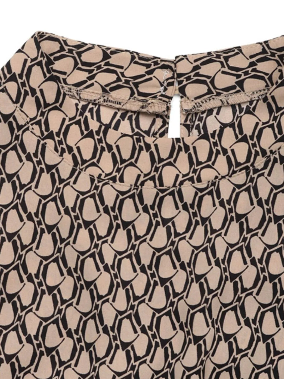 Close-up of the taupe and black geometric print with a keyhole neckline button
