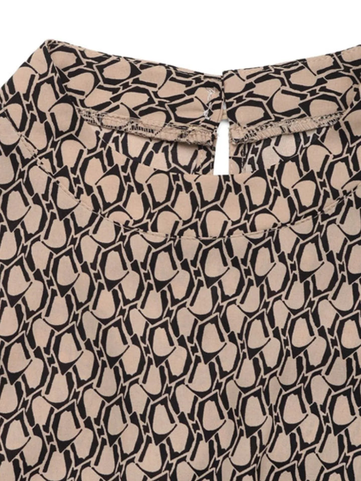 Close-up of the taupe and black geometric print with a keyhole neckline button