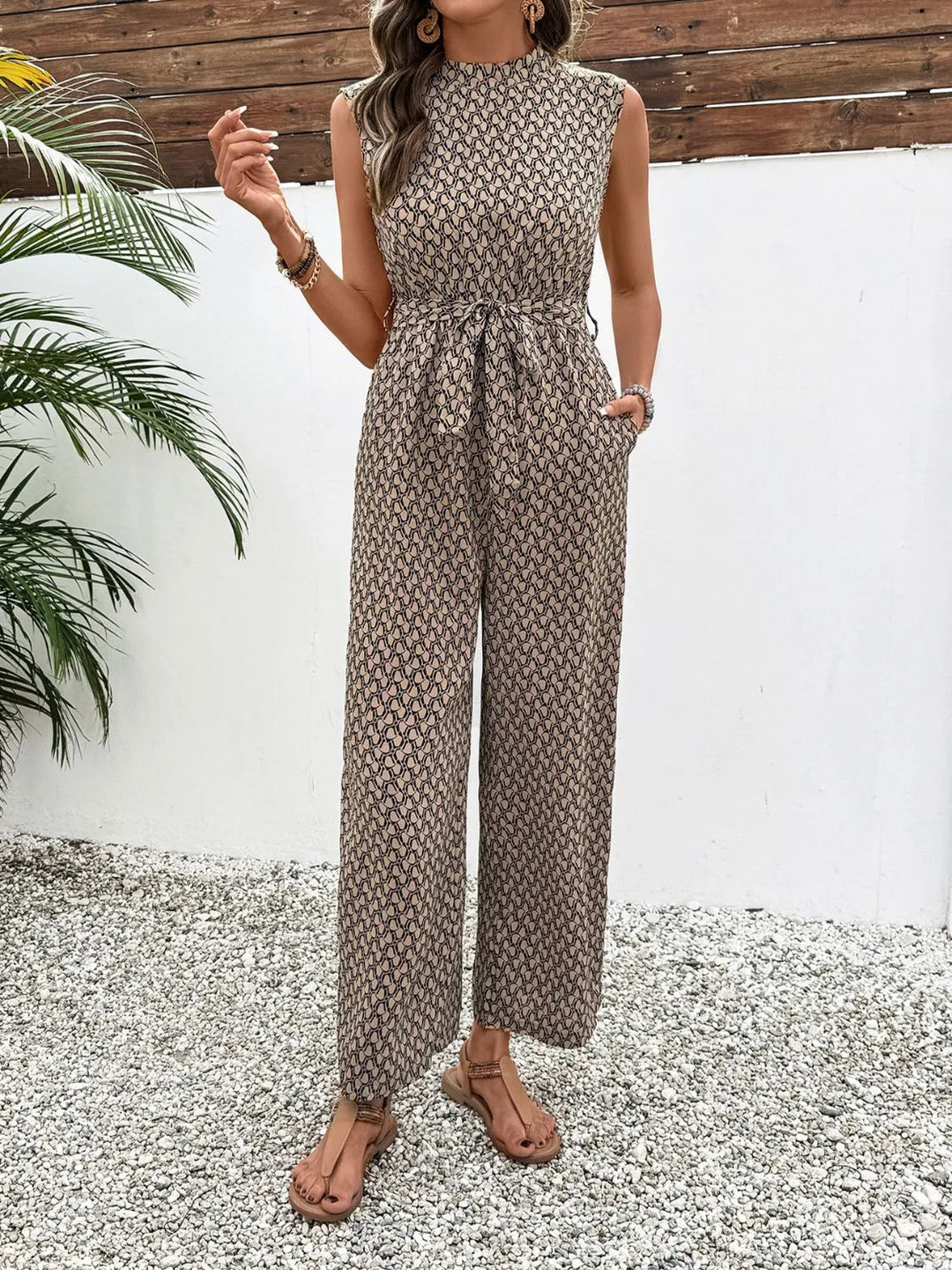 Women's wide leg jumpsuit in taupe print, sleeveless mock neck with tie belt, front view