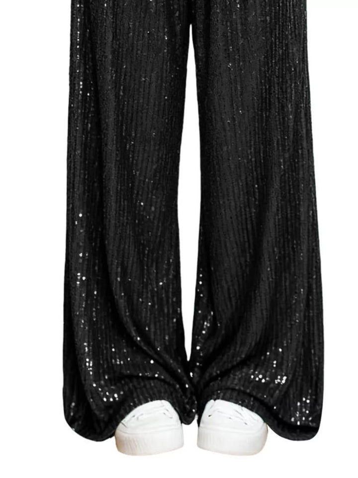 Black sequin wide leg pants hem over white sneakers