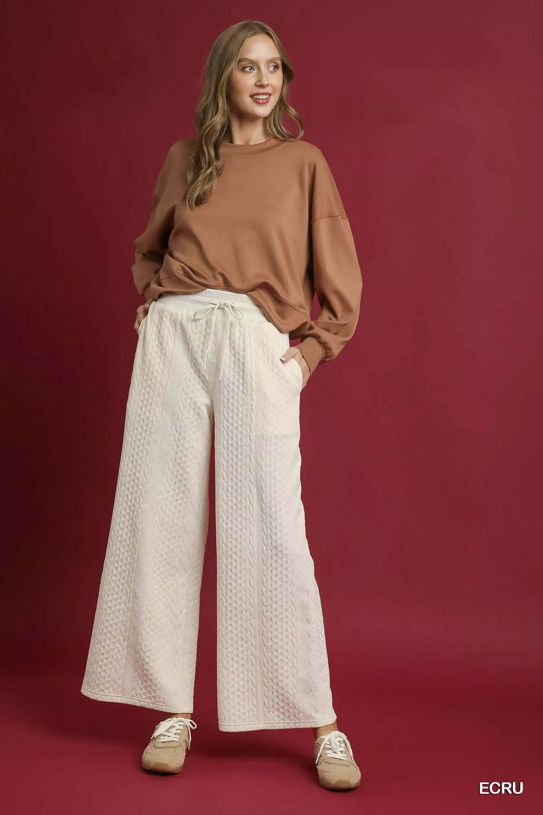 Ivory cable knit wide leg pants styled with a brown sweatshirt and sneakers