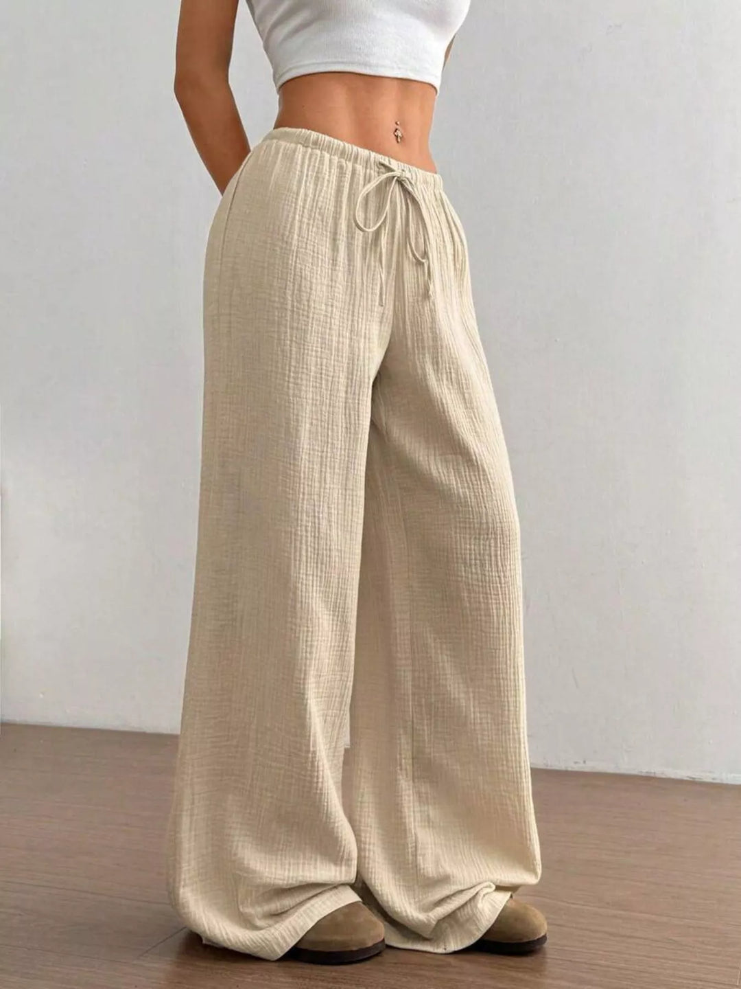 Beige wide leg pants with drawstring waist, front view with cropped white top