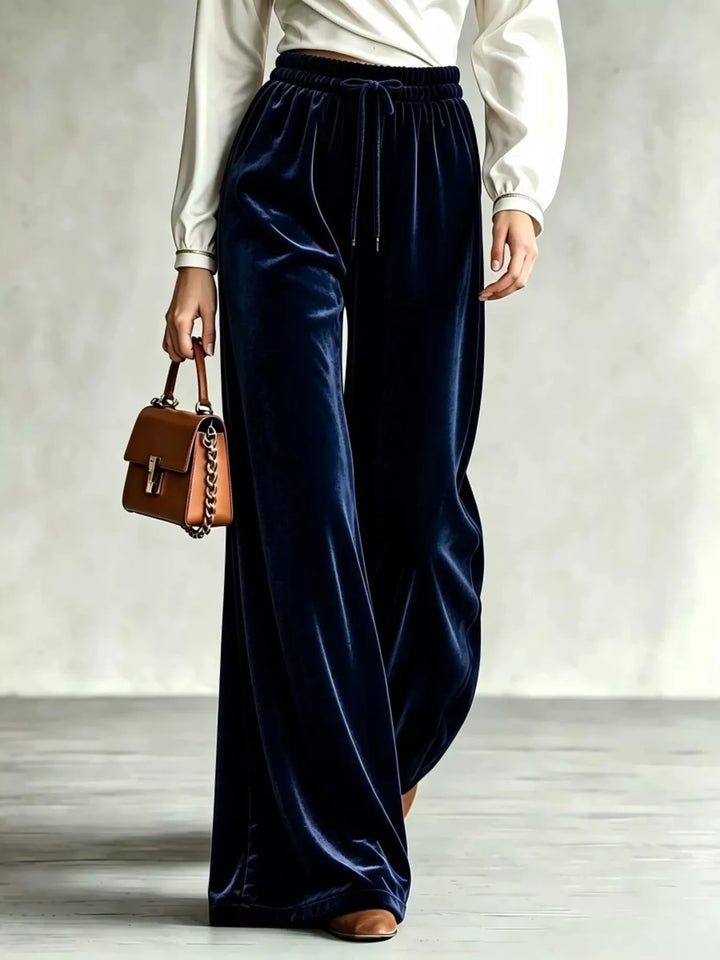 Navy velvet-look drawstring wide leg pants with a cream blouse and brown bag