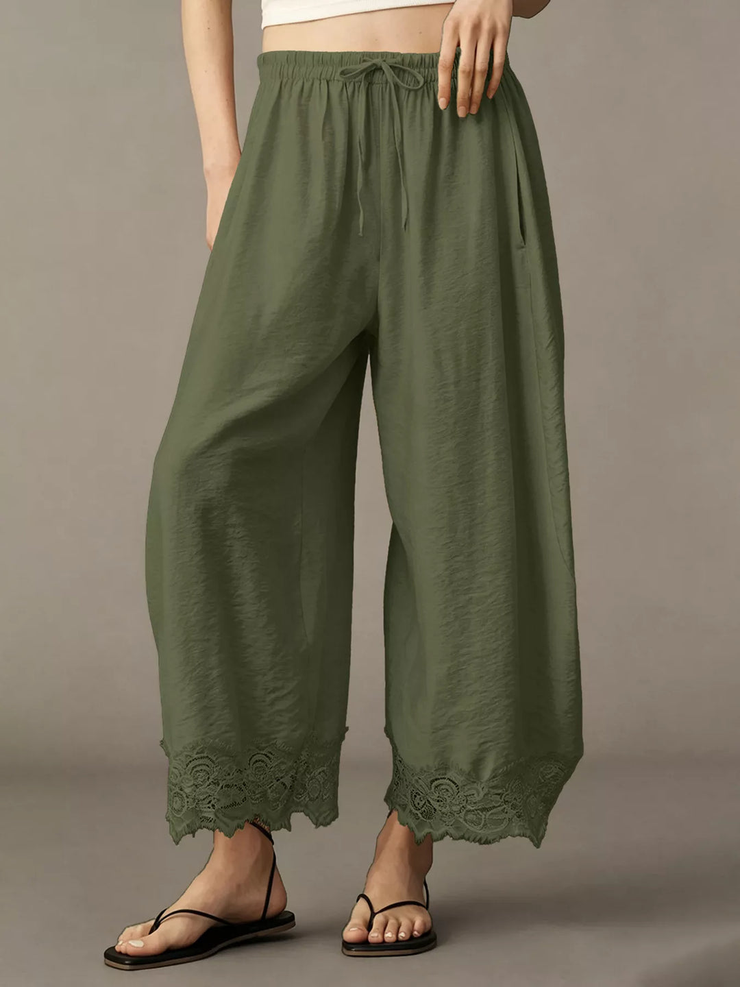 Army green pants with sandals showing the lace trim along the hem