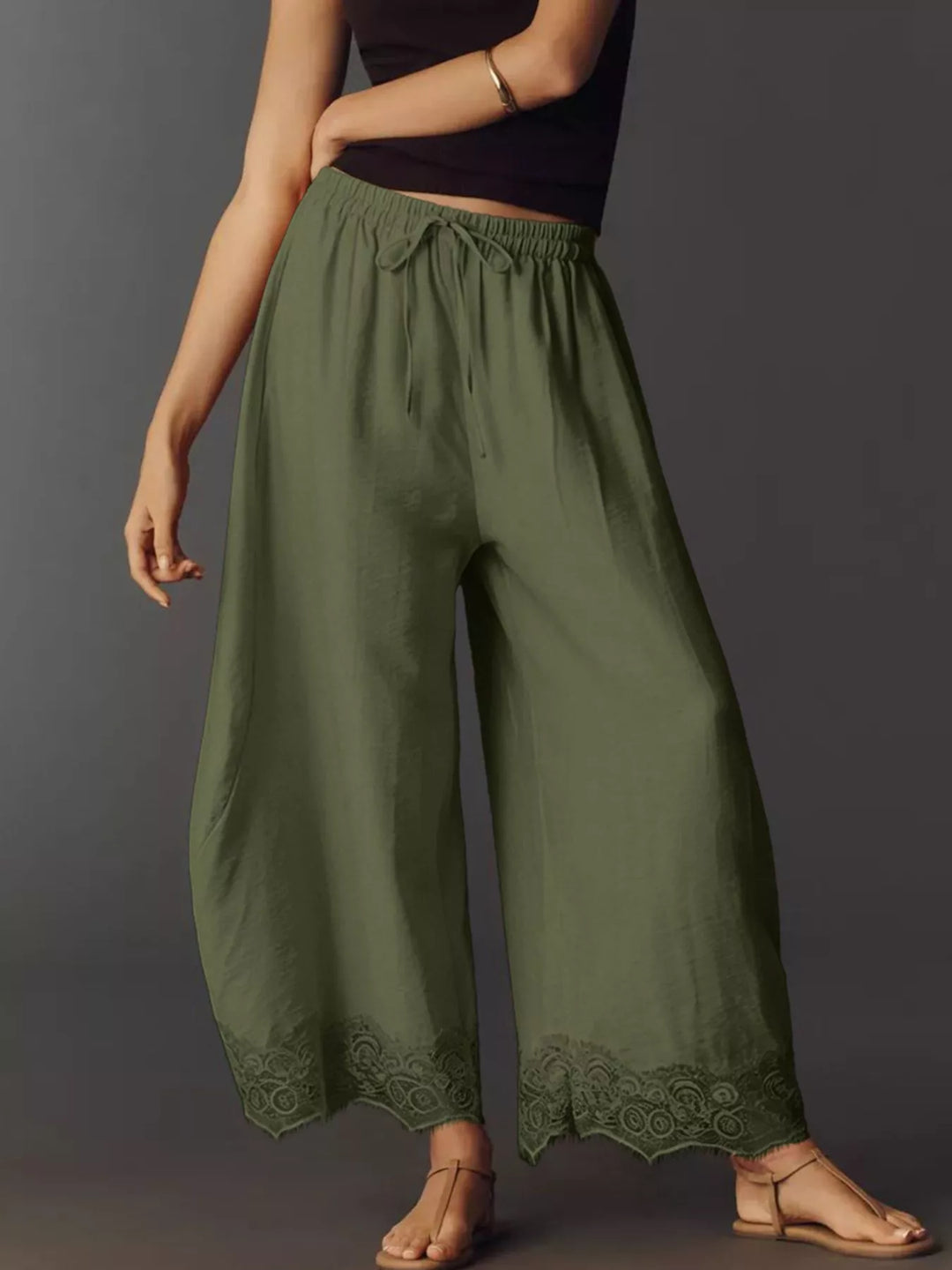 Army green drawstring pants in a three quarter view with tie detail