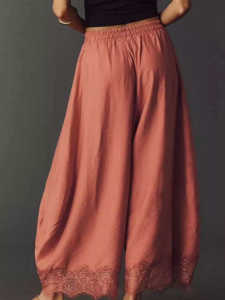 Back view of the burnt coral wide leg pants with the lace hem