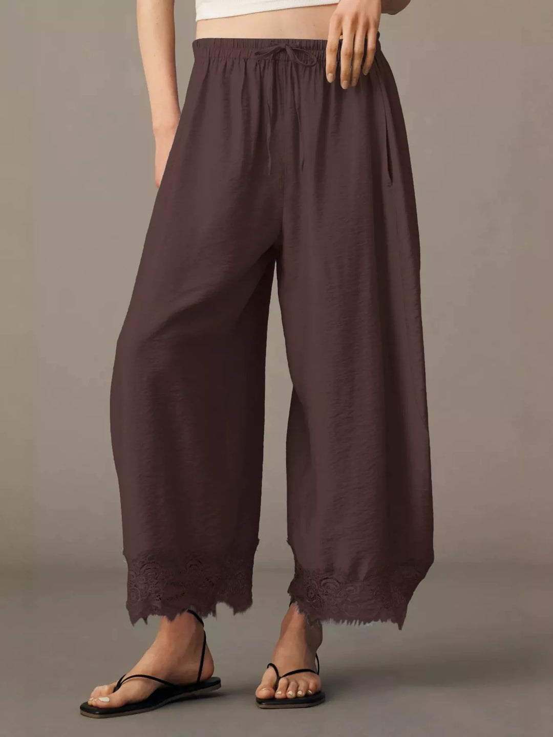 Chocolate brown wide leg pants front view with drawstring waist and lace hem