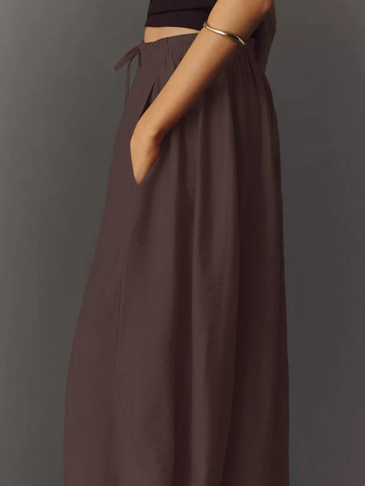 Side view of the chocolate pants with a hand in the pocket