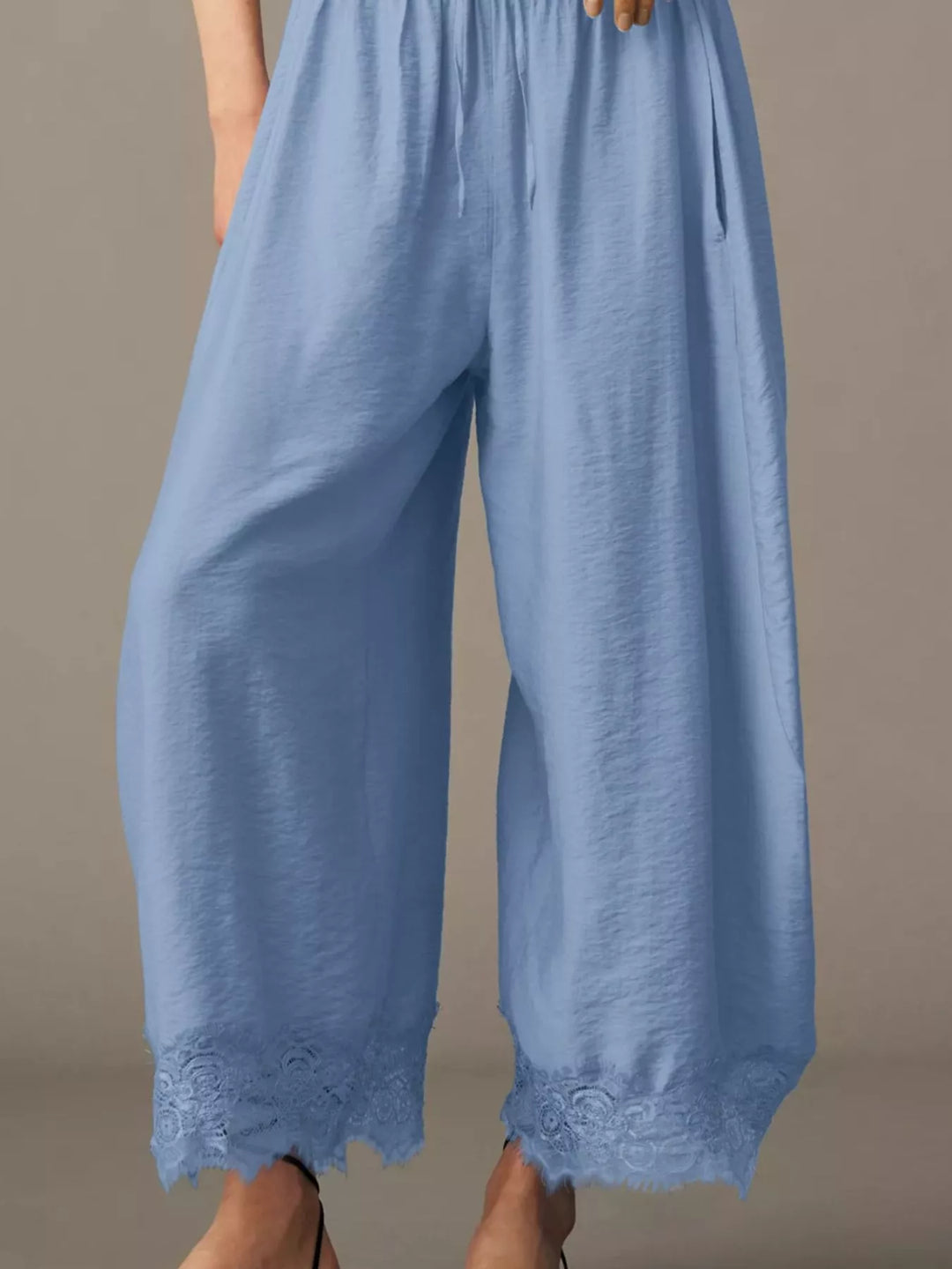 Close-up of the scalloped lace trim at the light blue pants hem