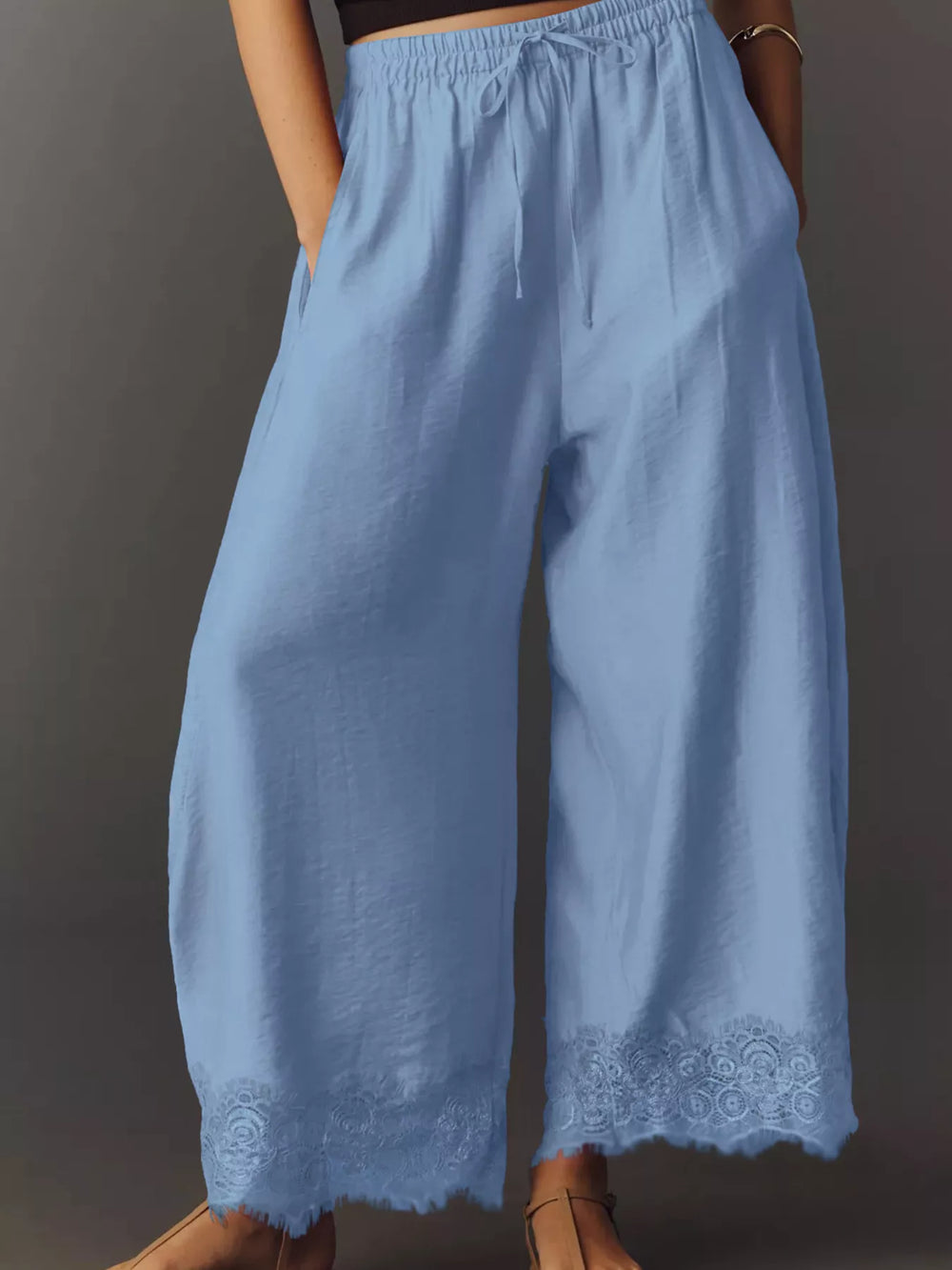 Light blue wide leg pants front view with drawstring waist and lace hem