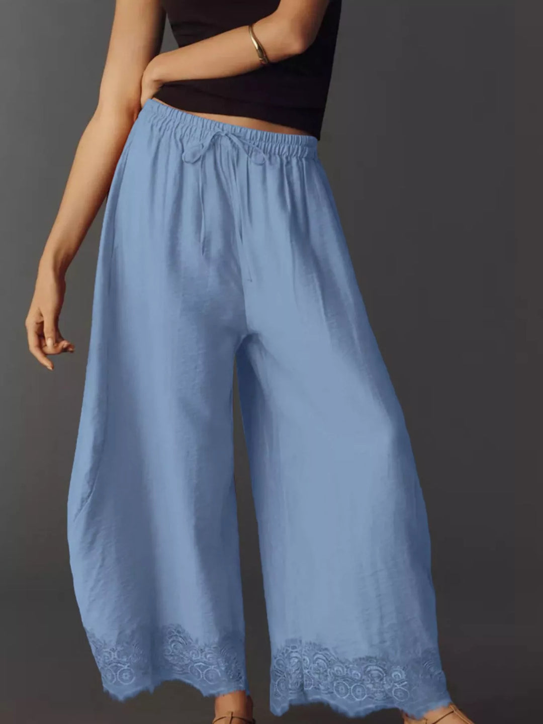 Side angle of the light blue drawstring pants with a hand in the pocket