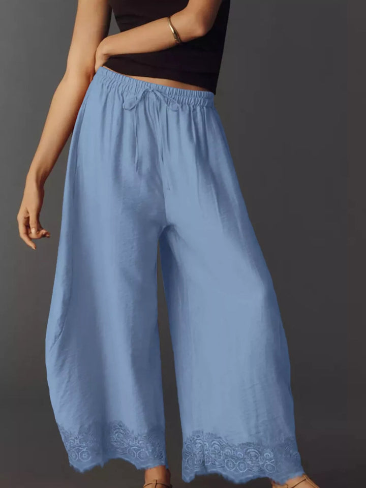 Side angle of the light blue drawstring pants with a hand in the pocket