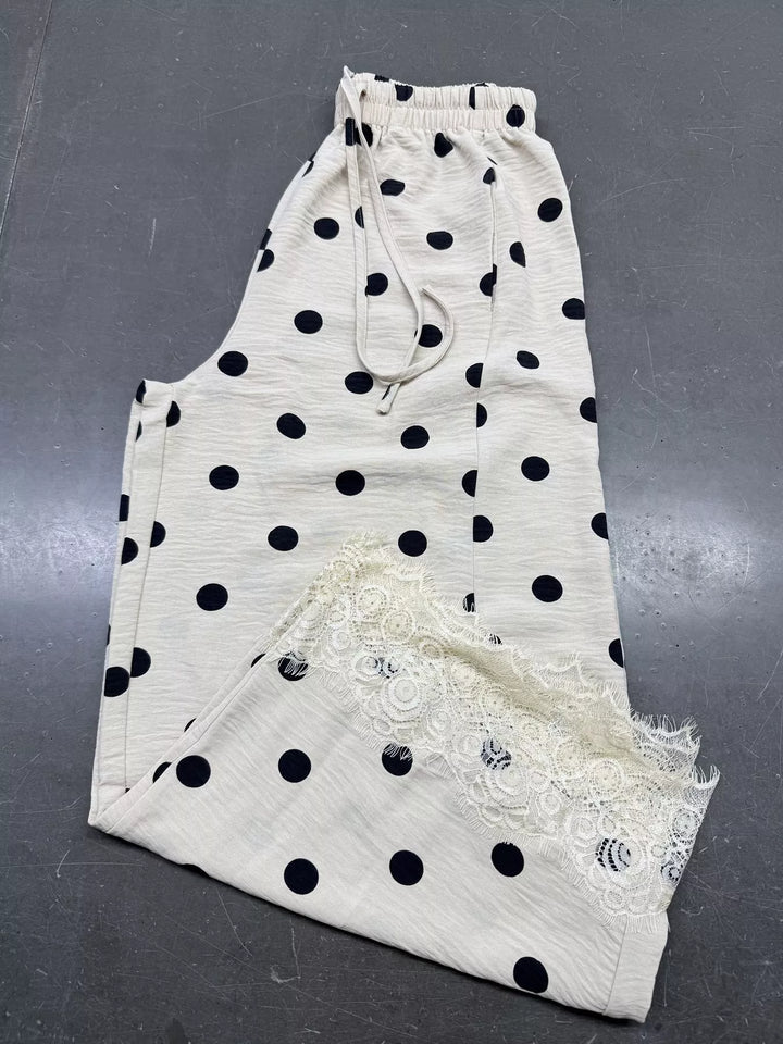 Polka dot wide leg pants laid flat showing the lace trimmed hem